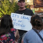 man with "IT'S LEGAL TO GO TOPLESS" sign for the women of NYC