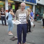 Old Man with FUCK BUSH sign gives the middle finger