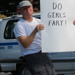Roman with DO GIRLS FART? sign