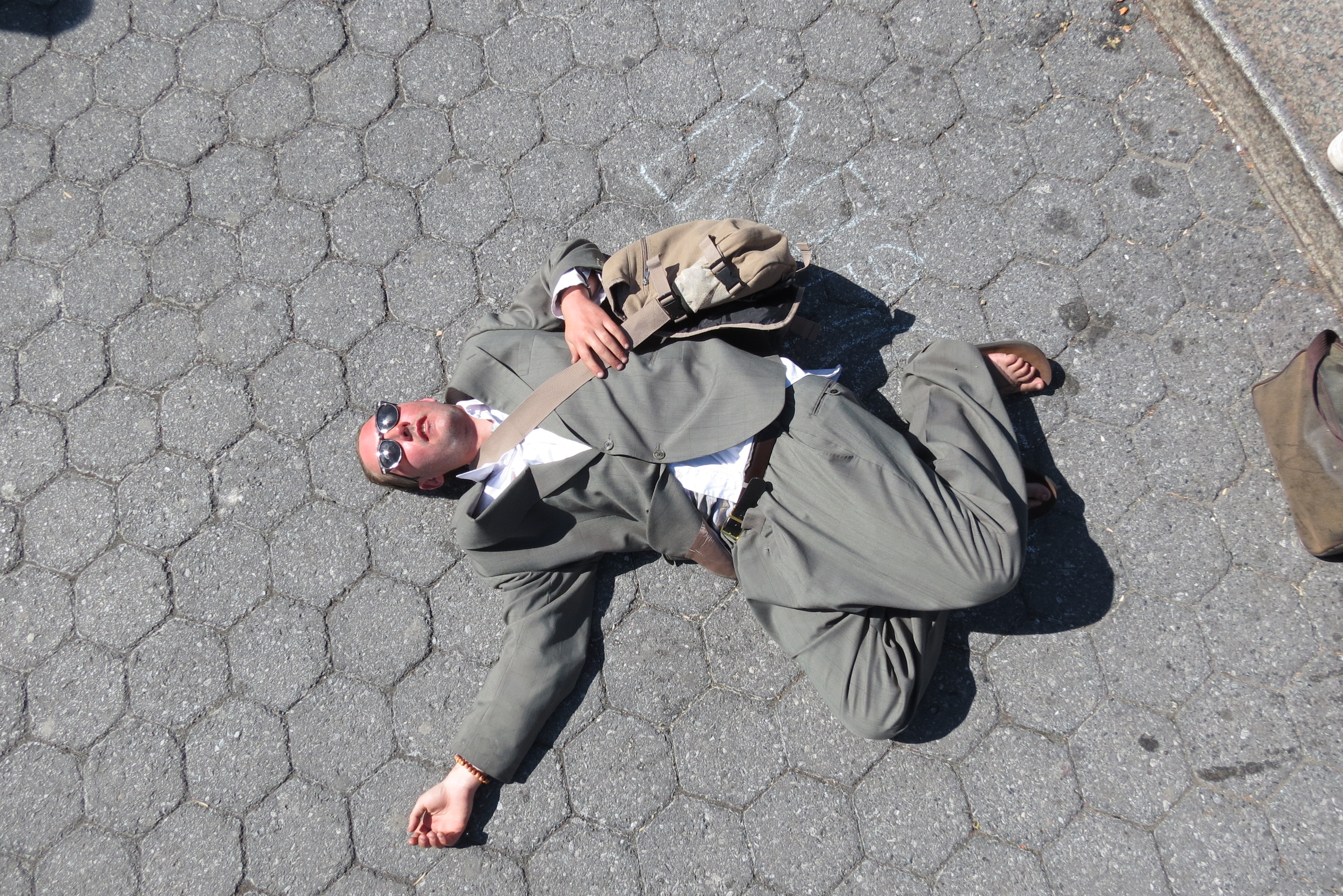 Lotion Man lying on floor of park