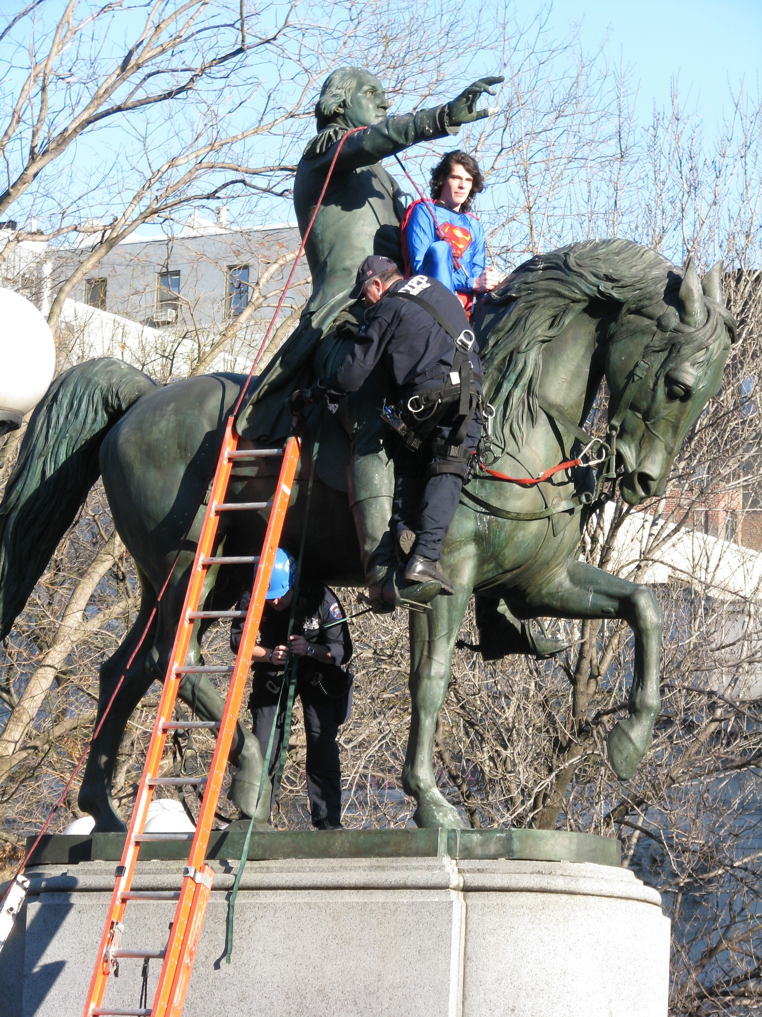Maksim Katsnelson dressed as Superman atop Washington statue with NYPD trying to take him down