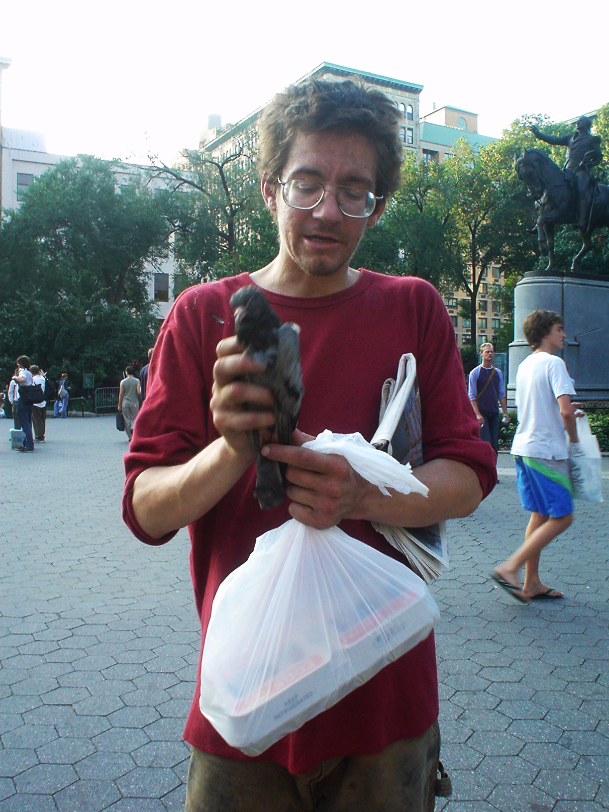 homeless man holding a sick pigeon