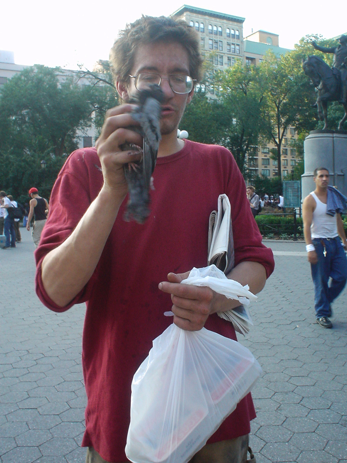 homeless man holding a sick pigeon
