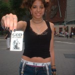 young girl with GOD IS FAKE flyer