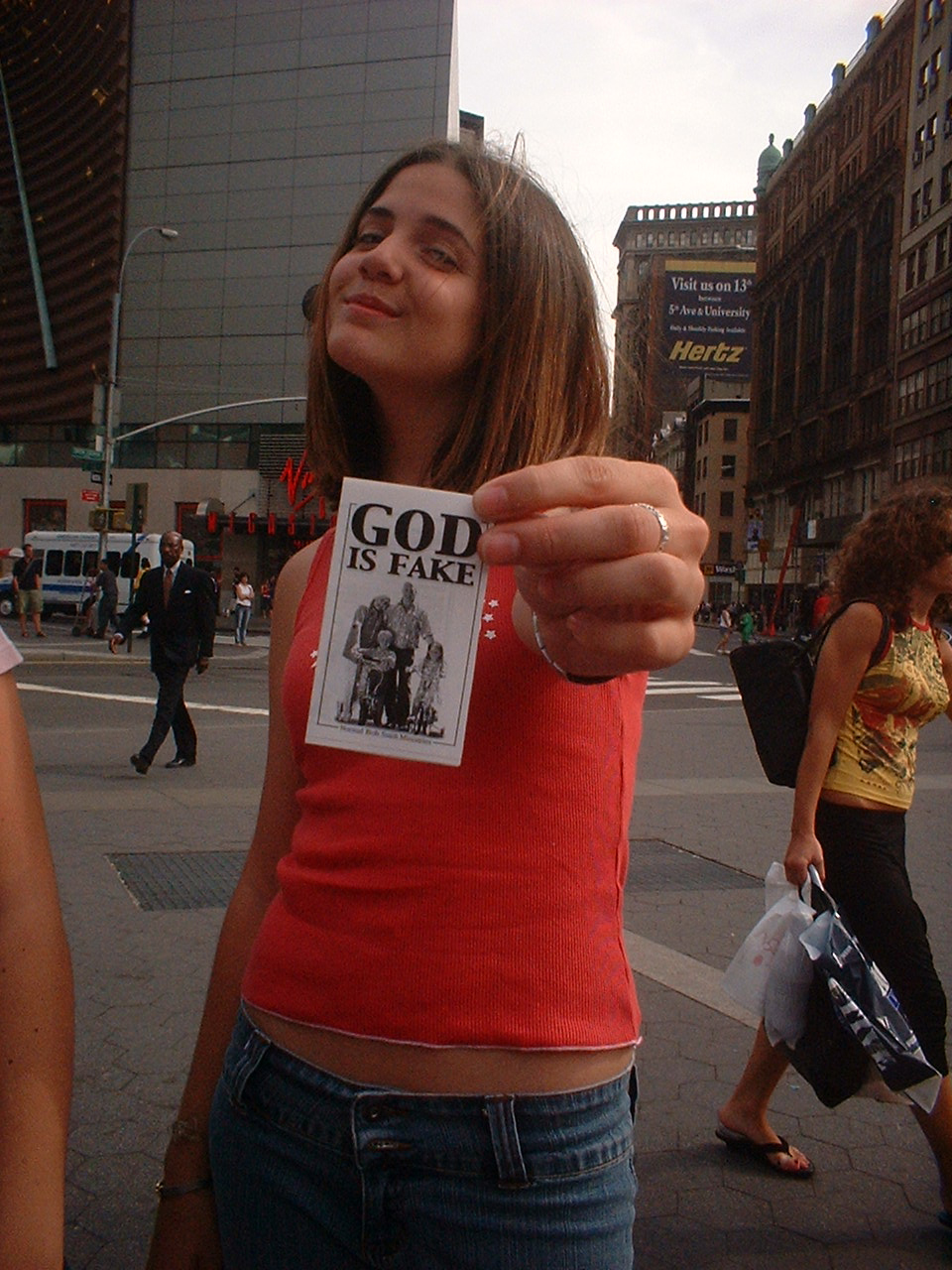 young girl with GOD IS FAKE flyer